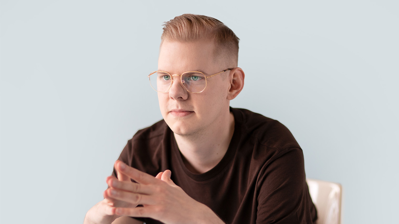 Silmälasipäinen mies nojaa eteenpäin.