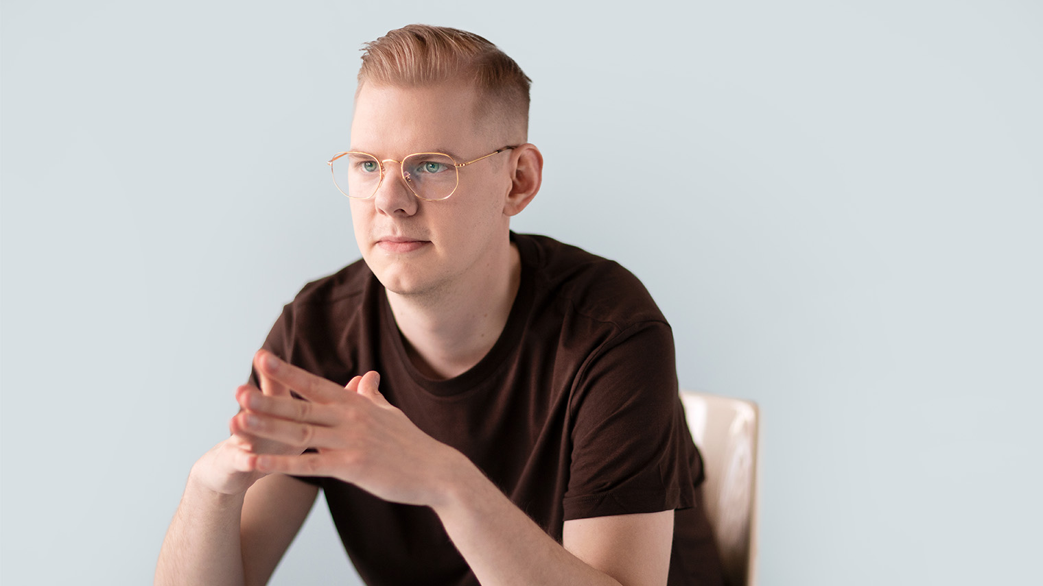 Mies nojaa tuolissa eteenpäin.