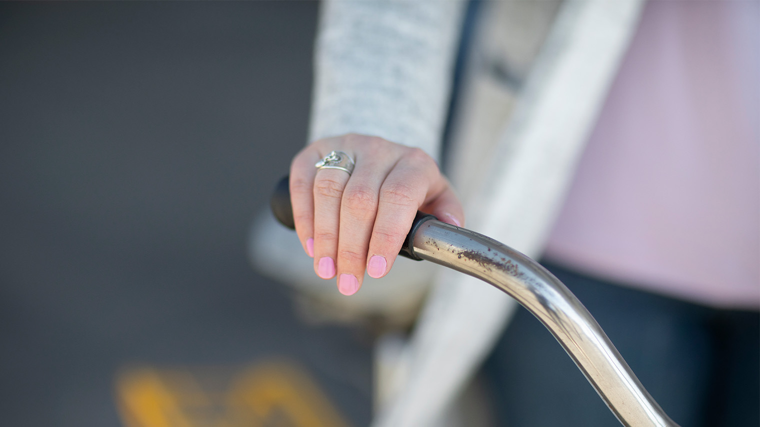 Käsi pyörän ohjaustangolla.