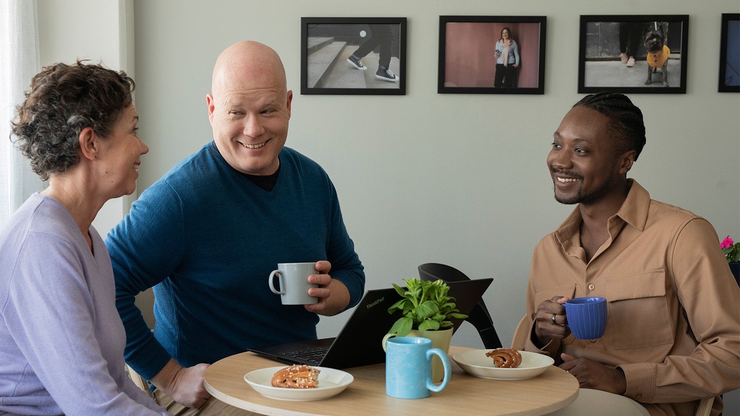 Työporukka kahvipöydään äärellä.