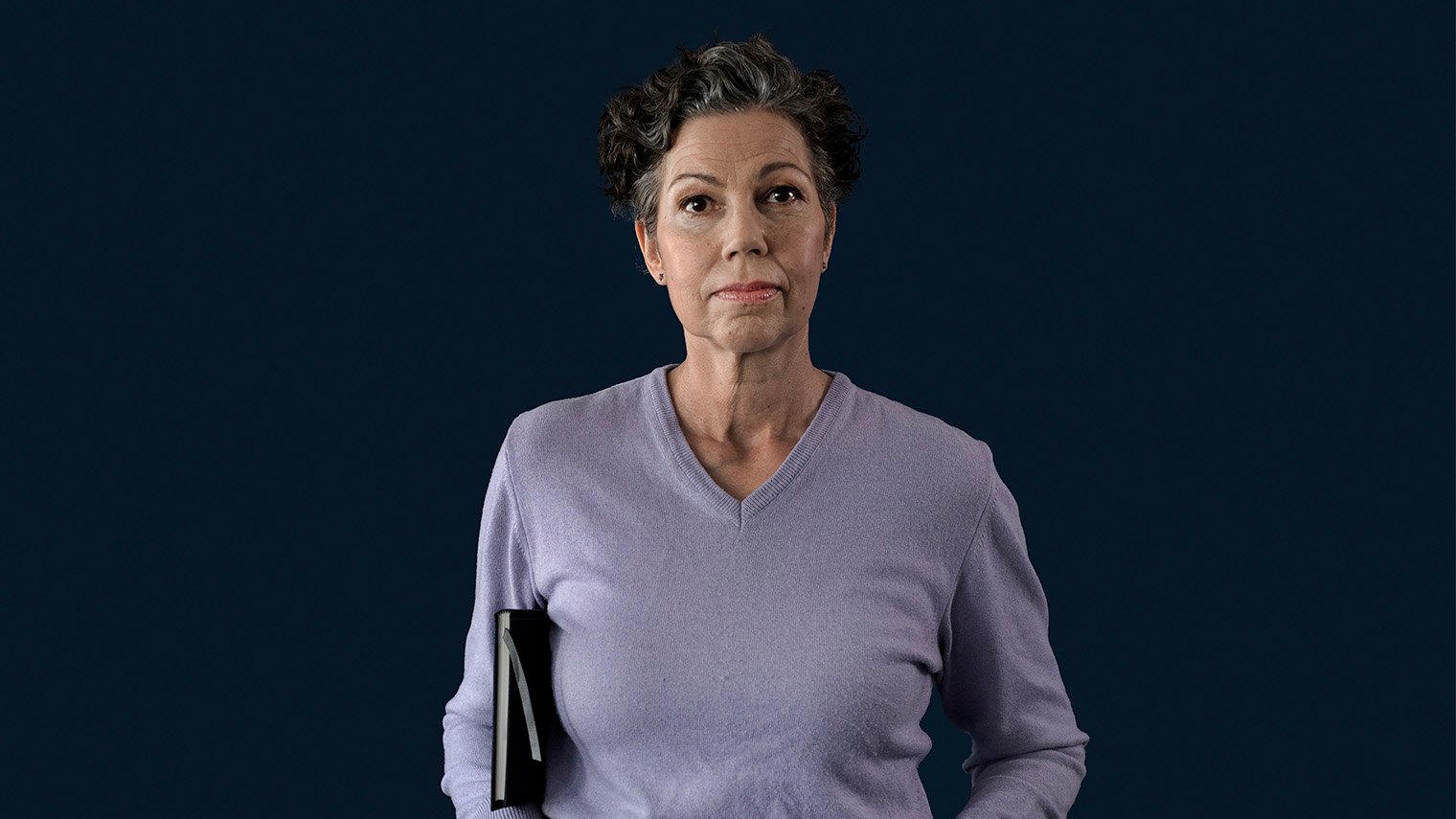 Vakava nainen kirja kainalossaan.